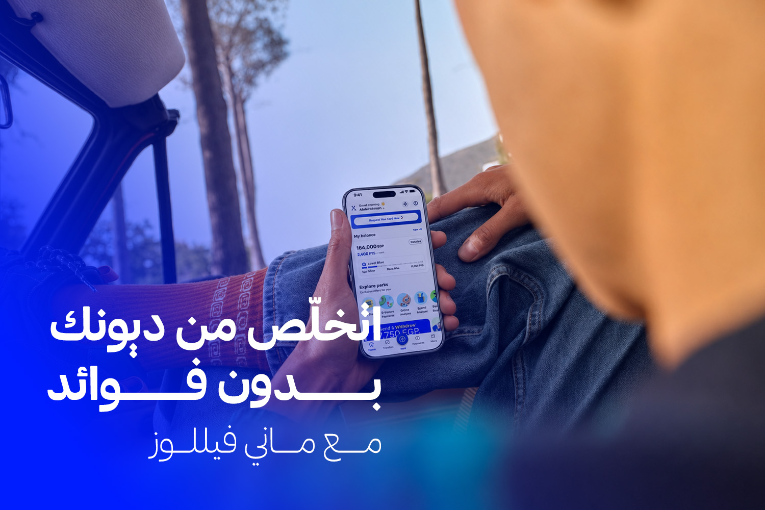 شخص ماسك موبايل ومفتوح على تطبيق ماني فيللوز المُرخص من البنك المركزي وبنك مصر من مقال: جمعيات تسديد ديون بالتقسيط من غير فوائد